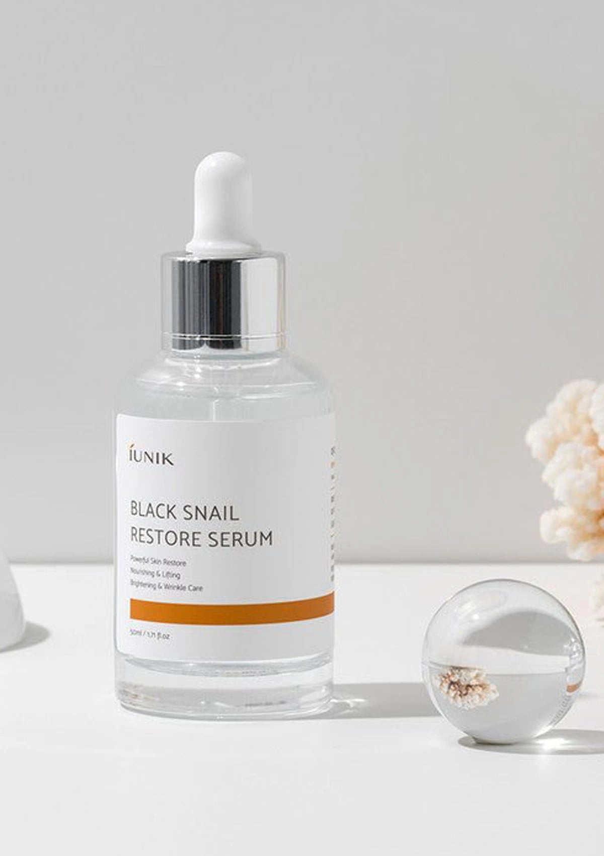 IUNIK Black Snail Restore Serum bottle on a light gray background